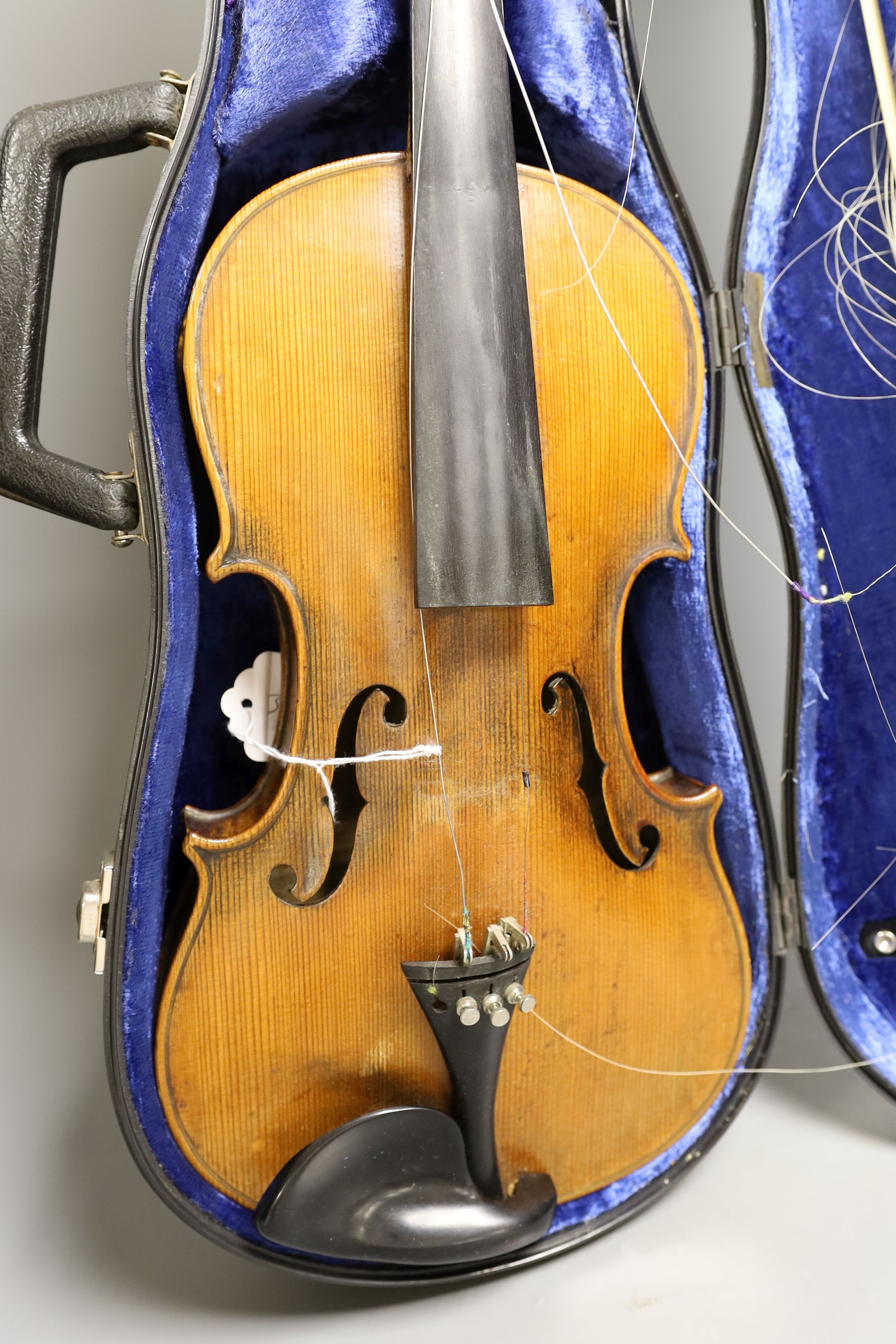 An early 20th century French or English violin with two bows, each stamped